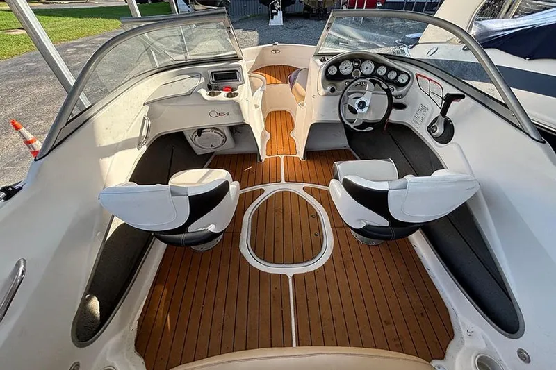 Slide: The Image of 2009 Tahoe Q5i Sport boat interior with wood flooring and white seating. - 2