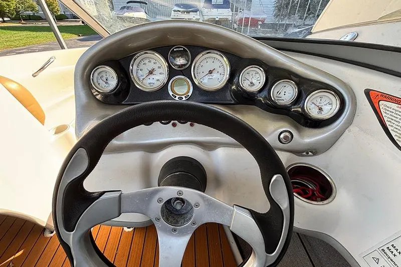 Slide: The Image of Steering wheel and dashboard of a 2009 Tahoe Q5i Sport boat, featuring multiple gauges. - 3