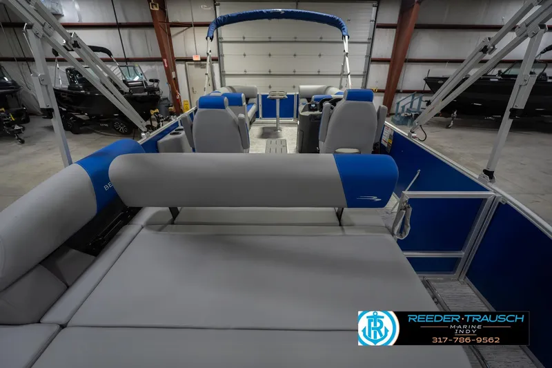 Slide: The Image of 2026 Bennington 23 SSB pontoon boat interior with blue and gray seating in a showroom. - 19