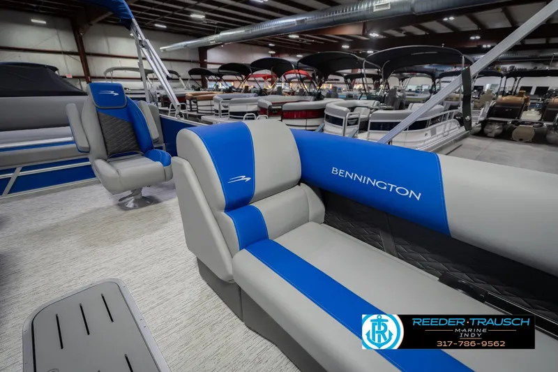 Slide: The Image of 2026 Bennington 23 SSB pontoon boat interior with blue and gray seating in showroom. - 24