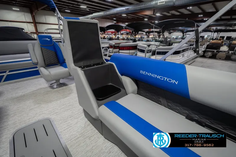 Slide: The Image of 2026 Bennington 23 SSB pontoon boat interior with blue and gray seating in showroom. - 25