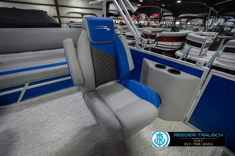 Slide: The Image of 2026 Bennington 23 SSB boat interior with blue and gray seating, cup holders visible. - 26