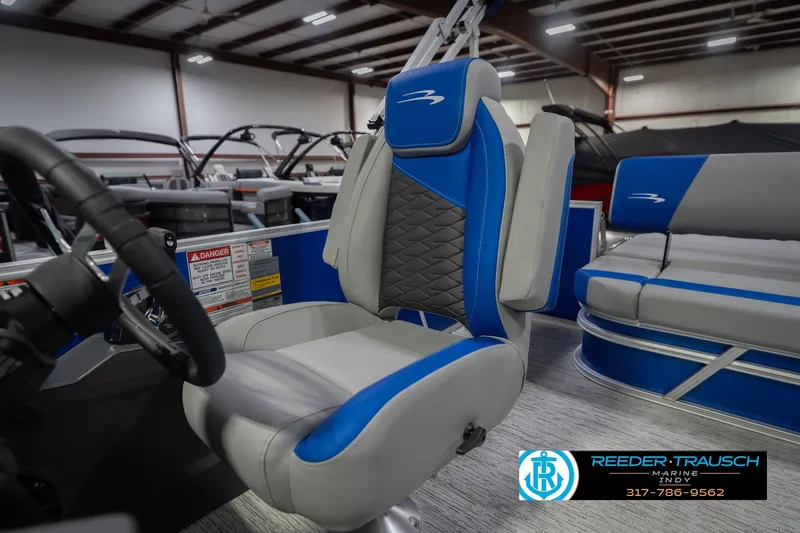 Slide: The Image of 2026 Bennington 23 SSB boat interior with blue and gray seating in showroom. - 39
