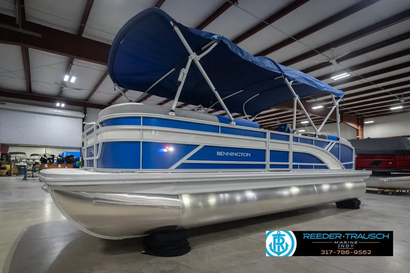 Slide: The Image of 2026 Bennington 23 SSB pontoon boat with blue canopy in showroom. - 4
