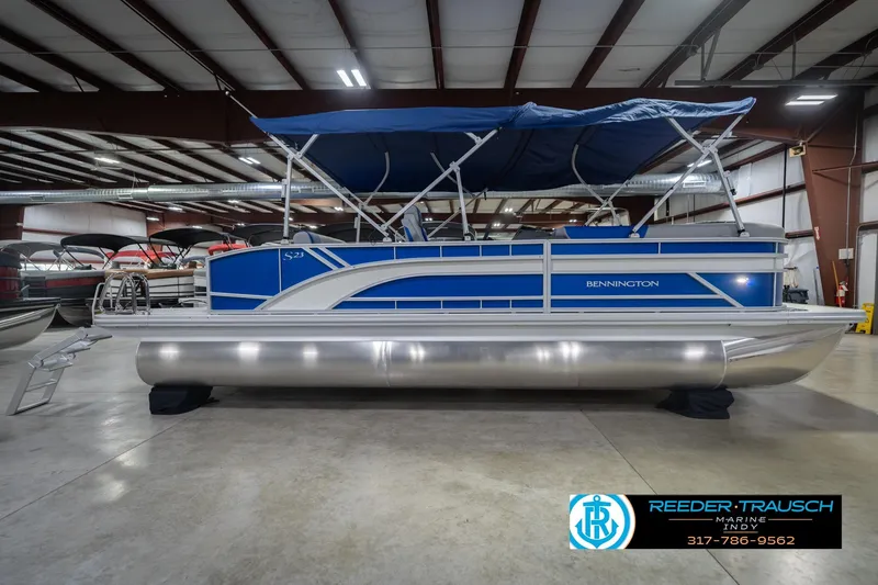 Slide: The Image of 2026 Bennington 23 SSB pontoon boat with blue canopy in showroom. - 7