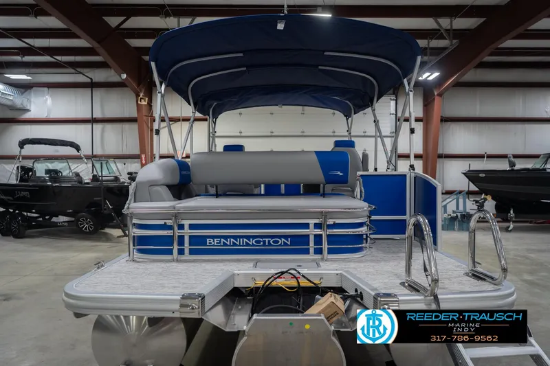 Slide: The Image of 2026 Bennington 23 SSB pontoon boat in showroom, featuring blue and gray design. - 9