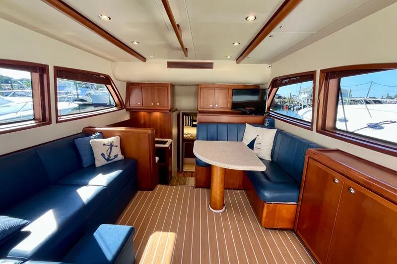 Slide: The Image of 2006 Bertram 390 Convertible boat deck with storage compartments, docked among other yachts. - 12