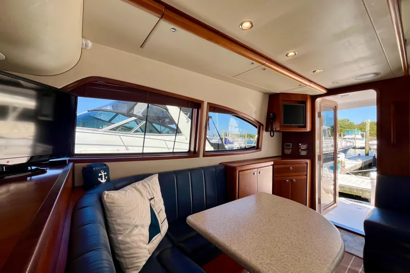 Slide: The Image of 2006 Bertram 390 Convertible yacht interior with dining area and blue seating. - 15