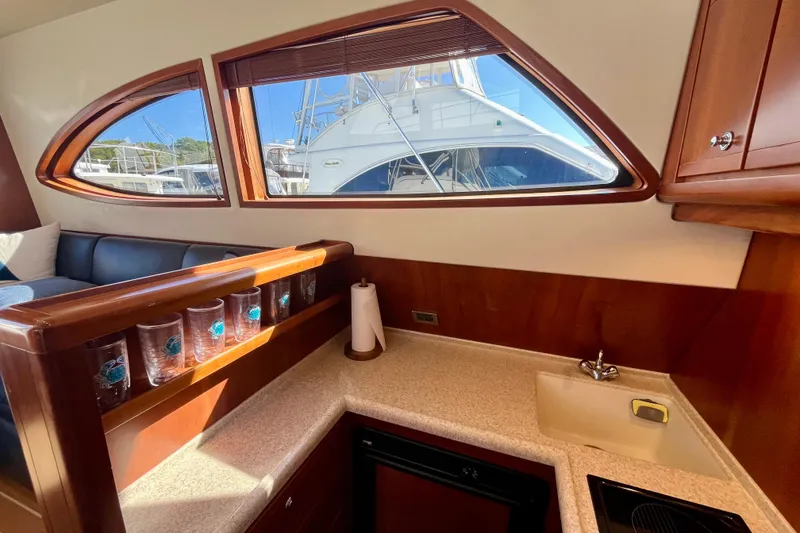 Slide: The Image of Interior of 2006 Bertram 390 Convertible yacht with elegant seating and marina view. - 16