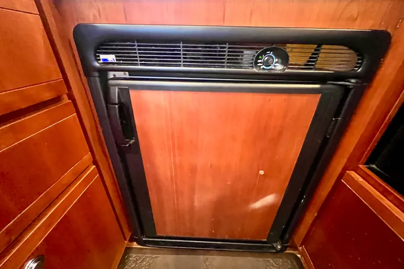 Slide: The Image of 2006 Bertram 390 Convertible yacht kitchen with wooden cabinets and modern appliances. - 18