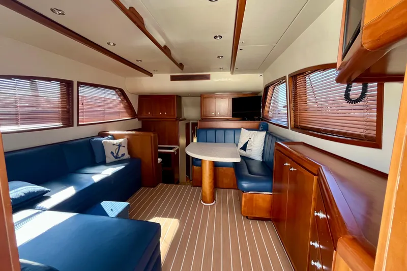 Slide: The Image of Interior of 2006 Bertram 390 Convertible yacht with blue seating and marina view. - 27