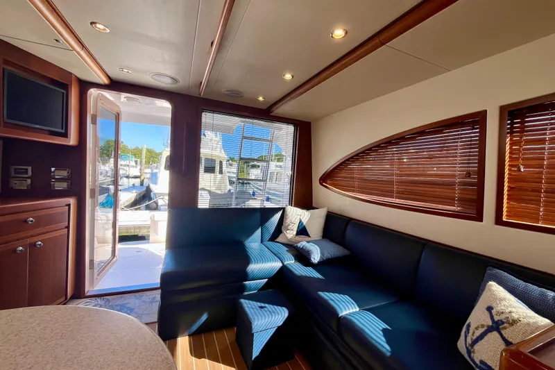 Slide: The Image of Interior of 2006 Bertram 390 Convertible yacht with elegant wood finish and blue seating. - 28