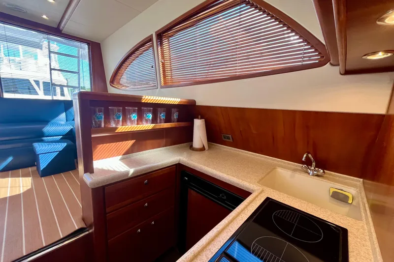 Slide: The Image of Interior of 2006 Bertram 390 Convertible yacht with blue seating and wooden blinds. - 29