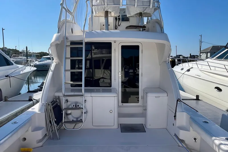 Slide: The Image of 2006 Bertram 390 Convertible yacht docked at marina under clear blue sky. - 3