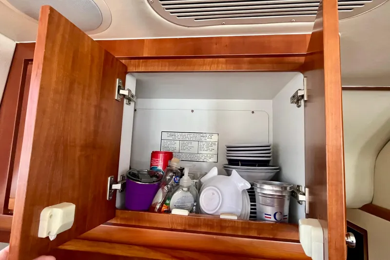 Slide: The Image of Open wooden cabinet with storage baskets inside Bertram 390 Convertible, 2006 model. - 31