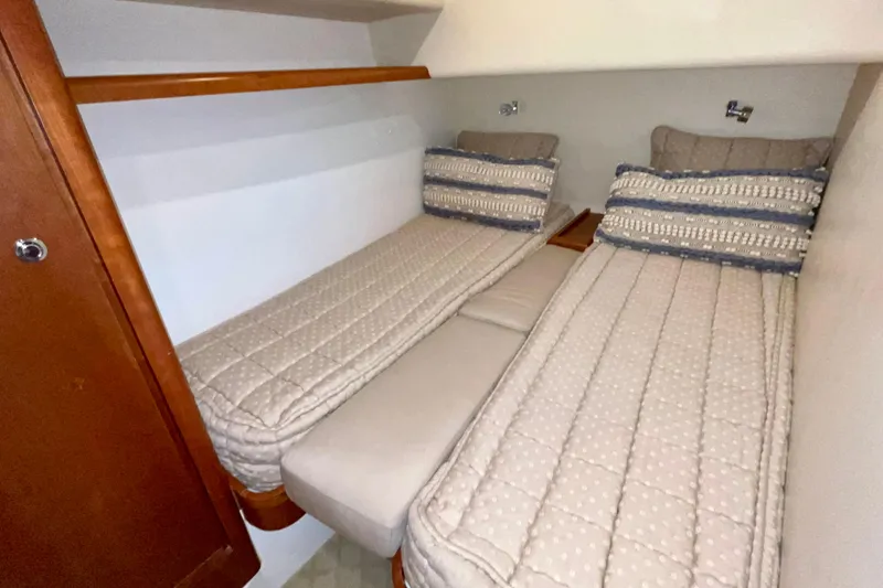 Slide: The Image of 2006 Bertram 390 Convertible cabin with twin beds and wooden cabinetry. - 38