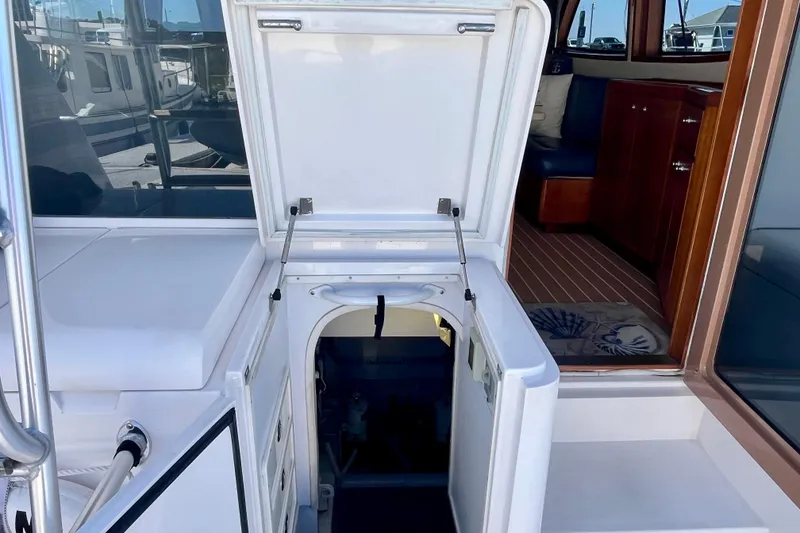 Slide: The Image of 2006 Bertram 390 Convertible yacht interior with striped cushions, docked at marina. - 47