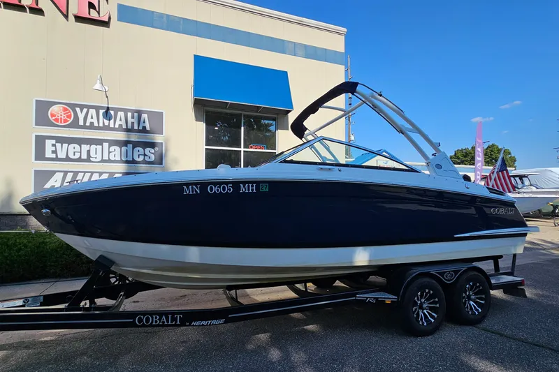 Slide: The Image of 2022 Cobalt R4 boat on trailer outside dealership, featuring sleek design and modern architecture. - 2
