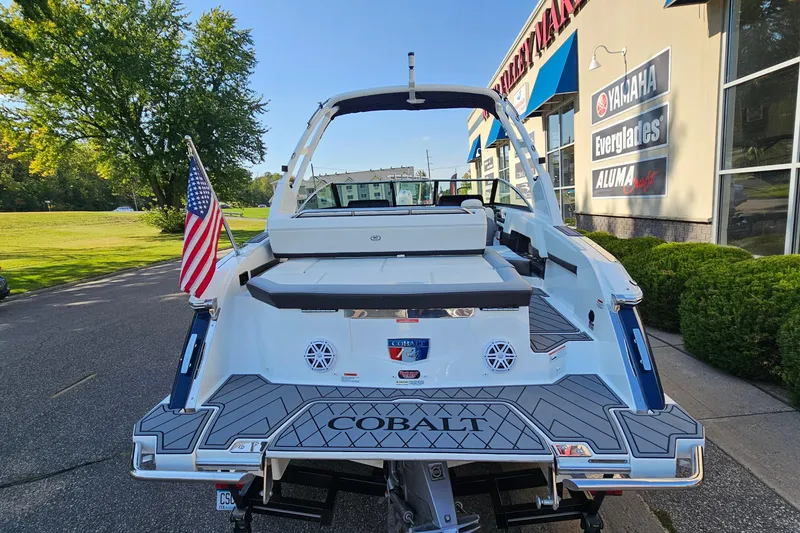 Slide: The Image of 2022 Cobalt R4 boat with American flag, parked near dealership, sunny day. - 5