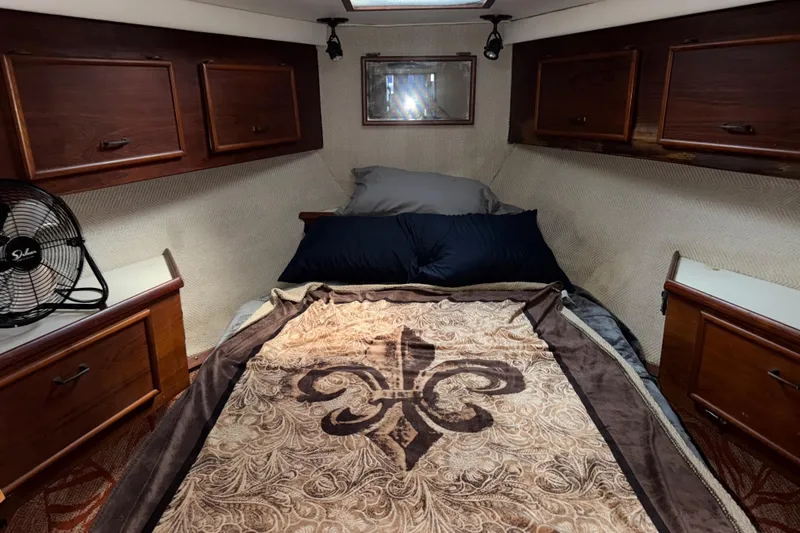 Slide: The Image of Cozy cabin interior of 1988 Ocean Convertible with wooden cabinets and decorative bedding. - 14