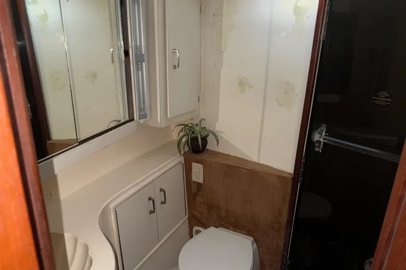 Slide: The Image of 1988 Ocean Convertible bathroom with mirror, cabinets, and potted plant. - 15