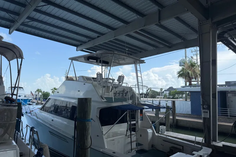 Slide: The Image of 1988 Ocean Convertible yacht docked under a covered marina with clear skies. - 4