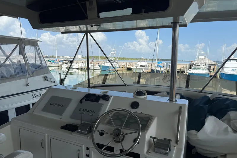 Slide: The Image of 1988 Ocean Convertible boat helm with Garmin navigation, docked at marina under blue sky. - 6