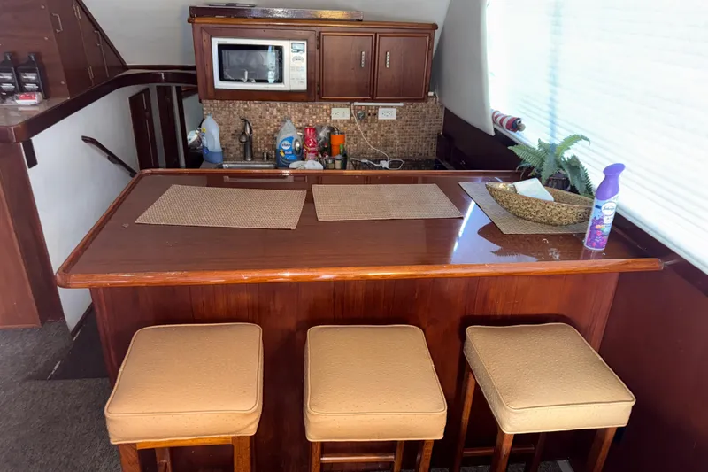 Slide: The Image of Interior of 1988 Ocean Convertible yacht with wooden bar, stools, and kitchenette. - 8