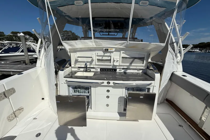 Slide: The Image of 2024 Boston Whaler 420 Outrage boat interior with kitchenette and storage compartments. - 24