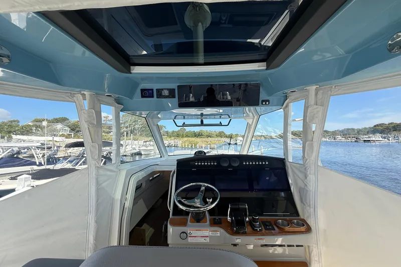 Slide: The Image of 2024 Boston Whaler 420 Outrage helm with advanced navigation system and panoramic marina view. - 33