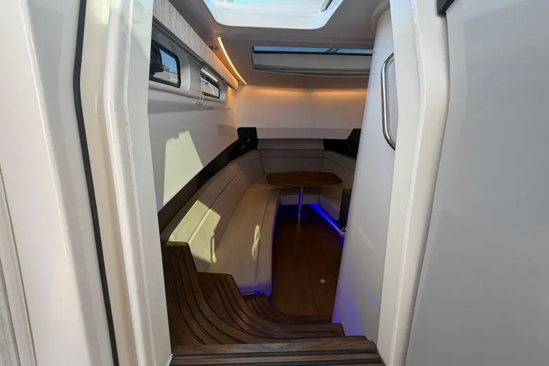 Slide: The Image of 2024 Boston Whaler 420 Outrage cabin interior with seating and ambient lighting. - 35