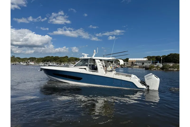 Slide: The Image of 2024 Boston Whaler 420 Outrage boat on calm water under blue sky. - 4