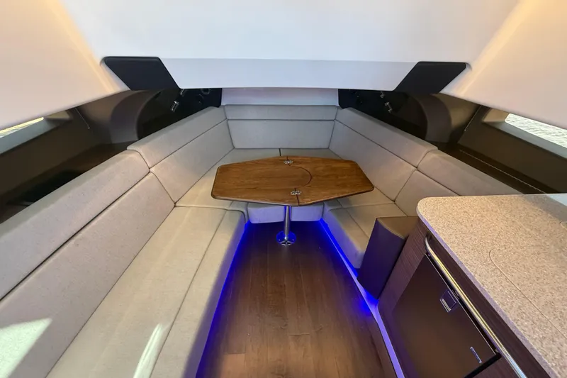 Slide: The Image of 2024 Boston Whaler 420 Outrage interior with cozy seating and wooden table. - 40