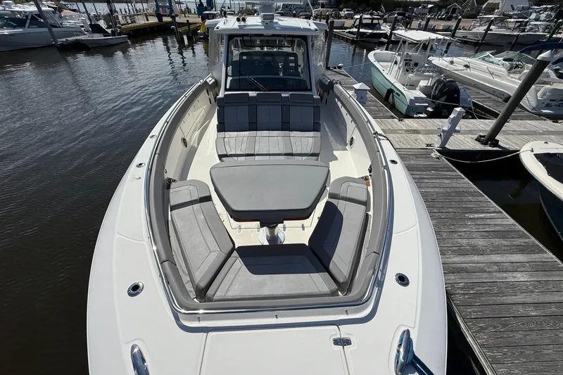 Slide: The Image of 2024 Boston Whaler 420 Outrage boat docked, featuring spacious seating and sleek design. - 47