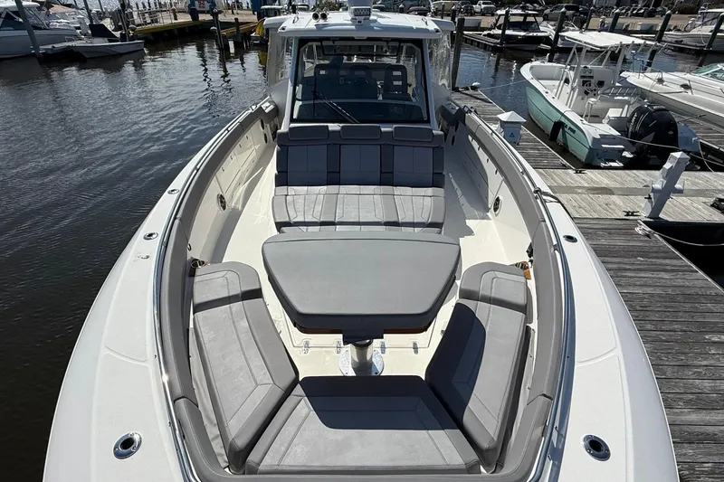 Slide: The Image of 2024 Boston Whaler 420 Outrage boat with spacious seating at a marina. - 48