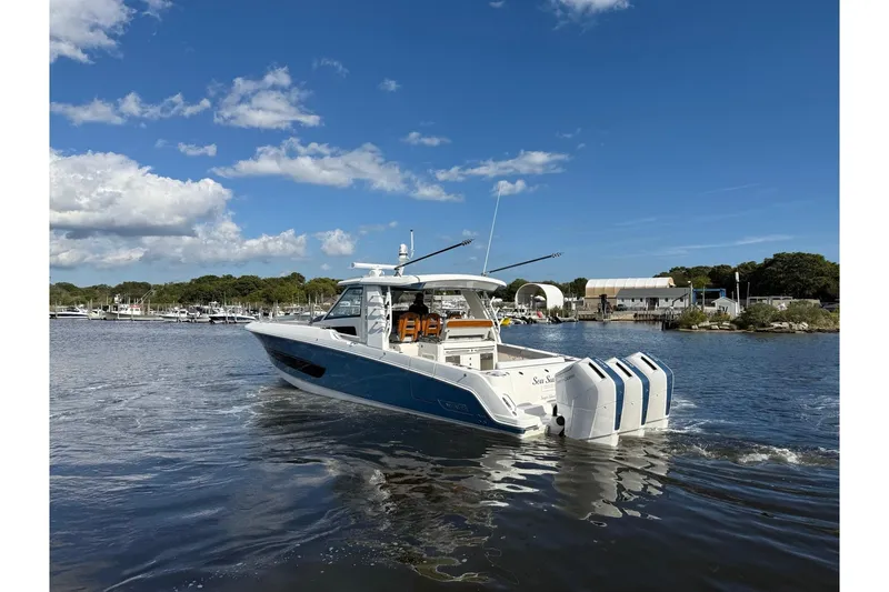 Slide: The Image of 2024 Boston Whaler 420 Outrage cruising on a sunny day near a marina. - 5