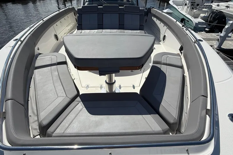 Slide: The Image of 2024 Boston Whaler 420 Outrage boat interior with cushioned seating and table. - 50