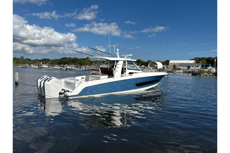 Slide: The Image of 2024 Boston Whaler 420 Outrage boat on calm water under a clear blue sky. - 52