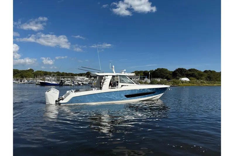 Slide: The Image of 2024 Boston Whaler 420 Outrage boat on calm water under clear blue sky. - 53