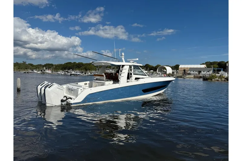 Slide: The Image of 2024 Boston Whaler 420 Outrage boat on calm water under a clear blue sky. - 7
