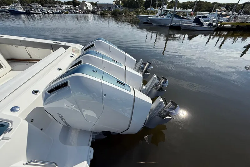 Slide: The Image of 2024 Boston Whaler 420 Outrage with triple outboard engines docked at marina. - 8