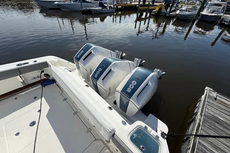 Slide: The Image of 2024 Boston Whaler 420 Outrage with triple Mercury 600 engines docked at marina. - 9
