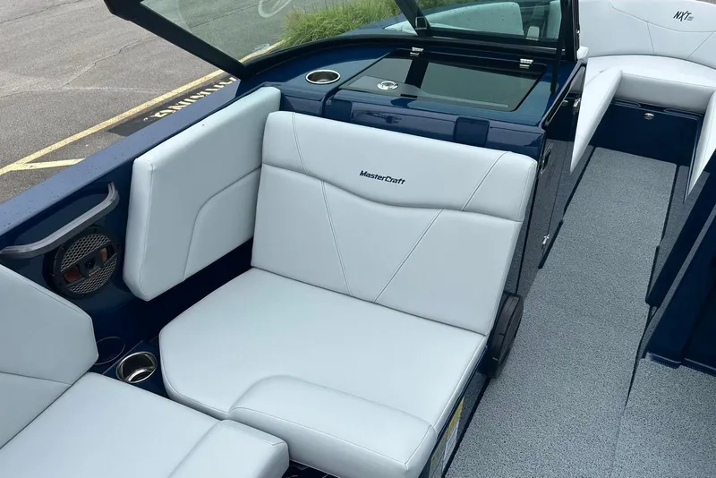 Slide: The Image of 2025 MasterCraft NXT23 boat interior with white seating and modern design. - 11