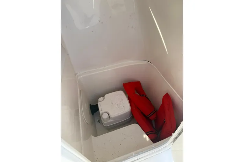 Slide: The Image of Storage compartment in 2013 Cobia 237 Center Console with life jackets and equipment. - 11