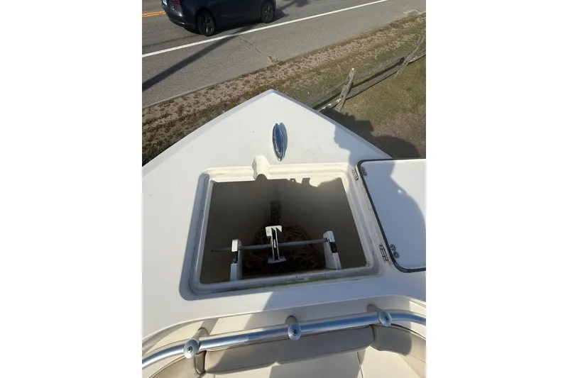 Slide: The Image of 2013 Cobia 237 Center Console boat anchor storage compartment open on deck. - 15