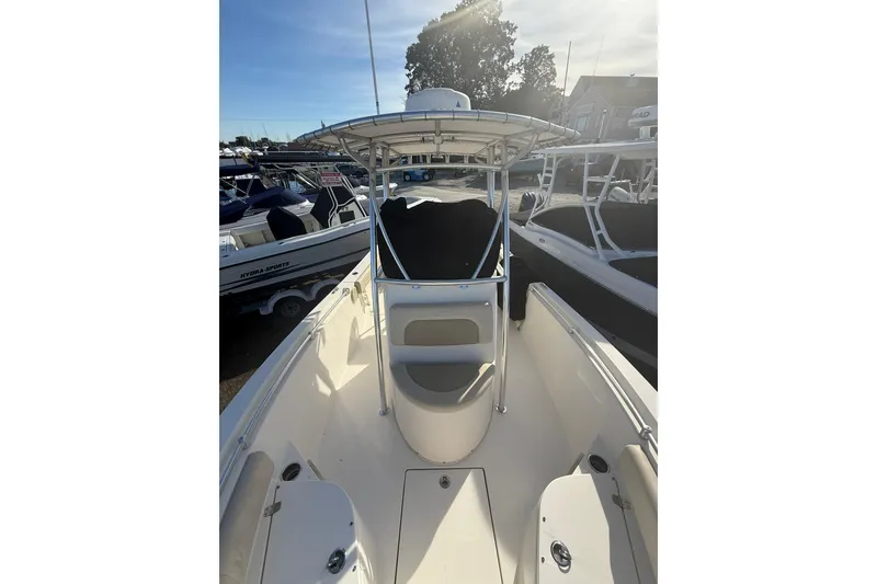 Slide: The Image of 2013 Cobia 237 Center Console boat with T-top, docked in marina. - 16