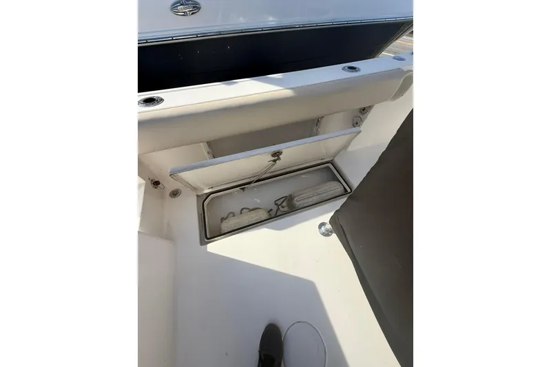 Slide: The Image of 2013 Cobia 237 Center Console boat storage compartment with open hatch. - 6