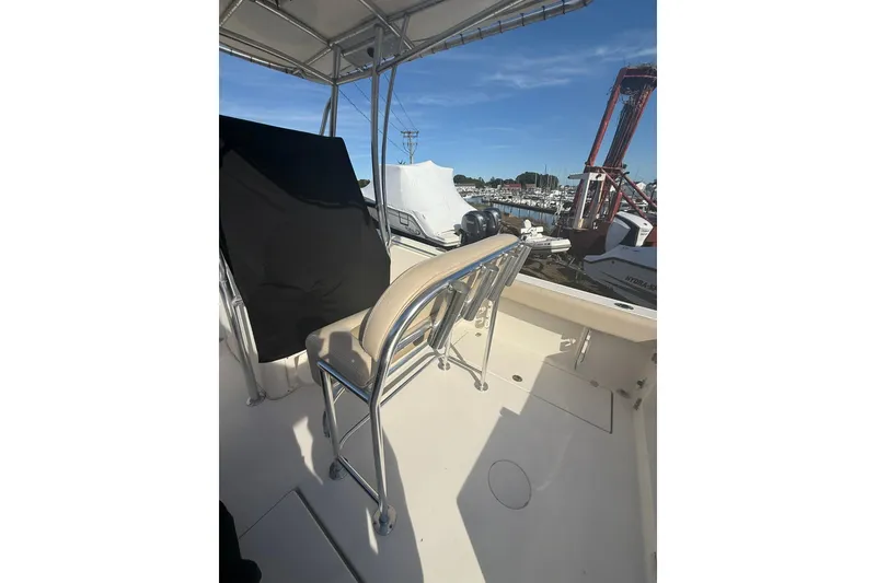 Slide: The Image of 2013 Cobia 237 Center Console boat interior with seating and marina view. - 7