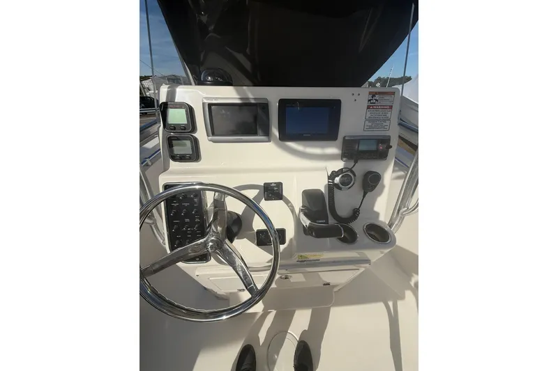 Slide: The Image of 2013 Cobia 237 Center Console boat dashboard with steering wheel and navigation controls. - 9