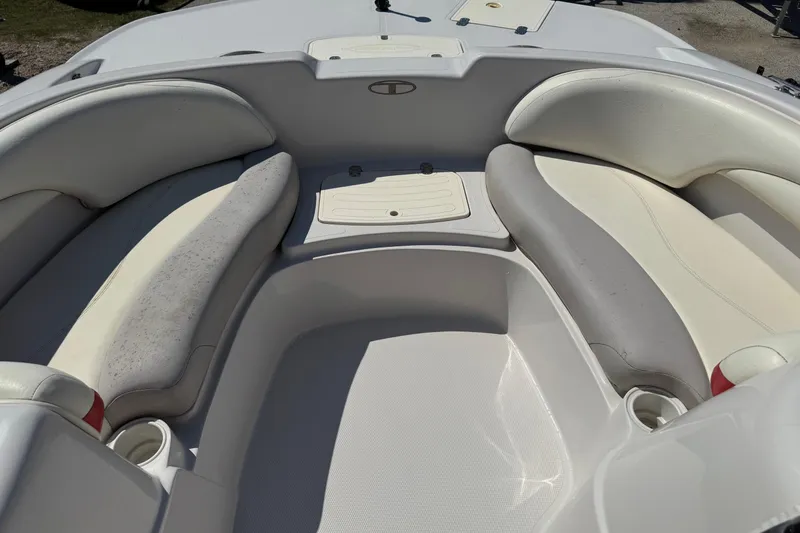 Slide: The Image of 2008 Tahoe 195 boat interior with white and gray seating, cup holders, and storage compartment. - 15